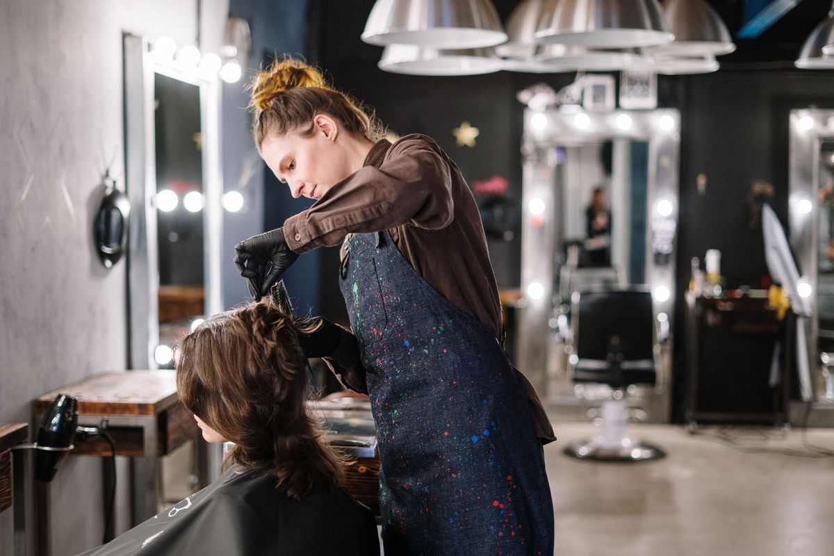 Colorist applying hair color to a client